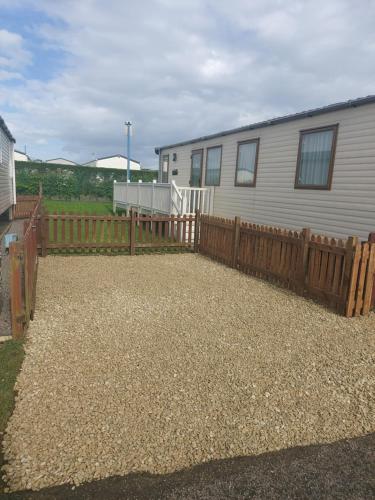 a yard with a fence and a house at 149 Holiday Resort Unity 6 berth Passes optional No pets in Brean