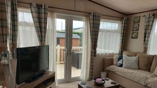 a living room with a flat screen tv and a couch at 149 Holiday Resort Unity 6 berth Passes optional No pets in Brean