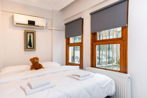 two beds in a room with a teddy bear sitting on them at La Villa Gardenia : 4Br Villa with Private Garden in Istanbul