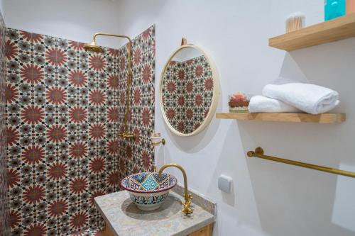 een badkamer met een wastafel en een spiegel bij Riad El Marah in Marrakesh