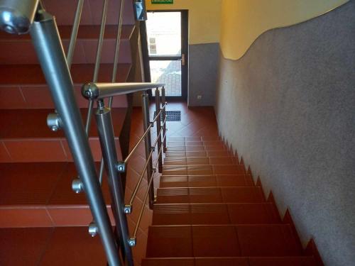 a staircase in a building with orange tiles and a stair railing at Miltex in Torzym