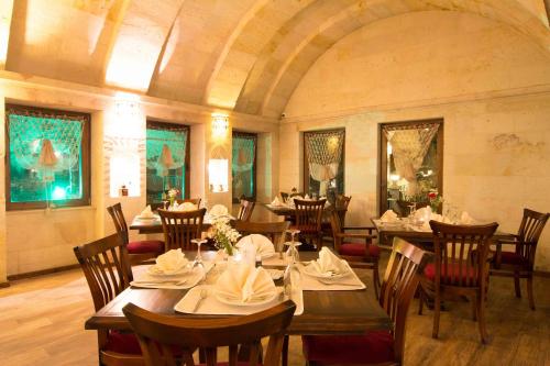 una sala da pranzo con tavoli e sedie in un edificio di Cappadocia Fairy Chimneys Minia Cave Hotel a Ortahisar