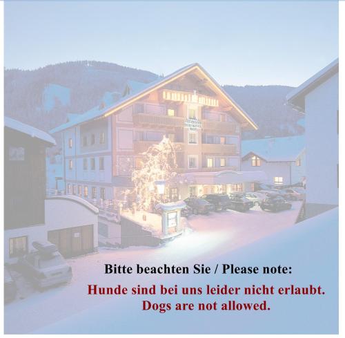 a large building with a christmas tree in front of it at Hotel Garni Serfauserhof in Serfaus