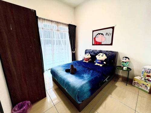 un dormitorio con una cama con animales de peluche en B1610 Austin Height Crayon shin chan Home By Stay, en Johor Bahru