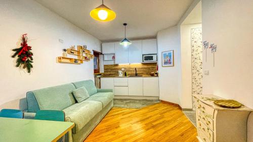 a living room with a couch and a kitchen at Appartamento Roma 79 - Affitti Brevi Italia in Bardonecchia