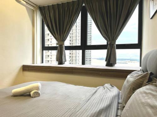 ein Schlafzimmer mit einem Fenster mit einem Bett und einem Handtuch in der Unterkunft SeaView Danga Bay - Heart of City - by Cowidea in Johor Bahru