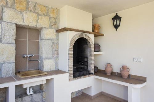 een keuken met een stenen open haard in een kamer bij Villa AUBELLONS in Alcudia