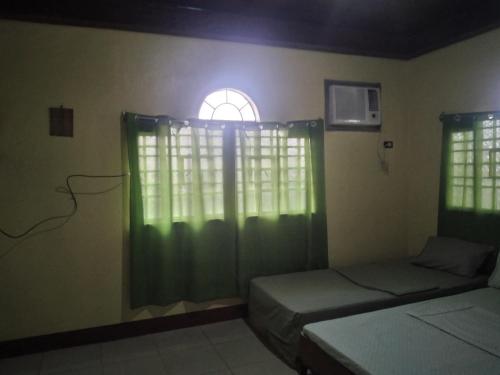 a bedroom with two beds and a window at Camille's Cheapstay in Alaminos