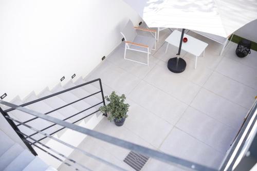 an overhead view of a white tile floor with a table and a chair at Le Tartane B&b Guidaloca in Castellammare del Golfo