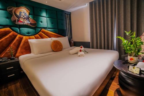 a bedroom with a large white bed in a room at Hanoi Center Silk Classic Hotel & Travel in Hanoi