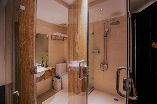 a bathroom with a shower and a toilet and a sink at Hanoi Center Silk Classic Hotel & Travel in Hanoi