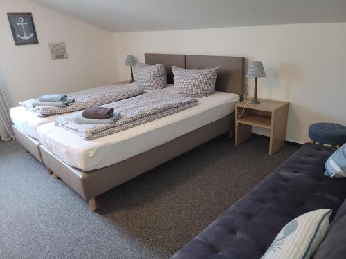 ein Schlafzimmer mit einem großen Bett und einem blauen Sofa in der Unterkunft Pension Turm in Schönwald