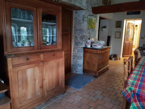 une grande armoire en bois dans une pièce avec une table dans l'établissement Chambre double dans longère, à Soulaines-sur-Aubance