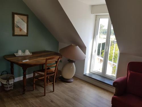 une chambre avec une table, une lampe et une fenêtre dans l'établissement Chambre double dans longère, à Soulaines-sur-Aubance