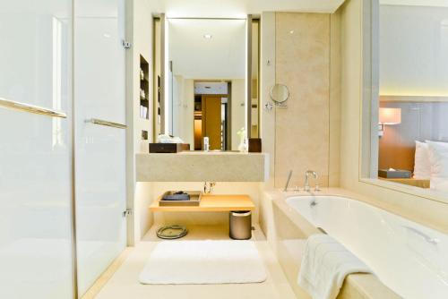 ein Badezimmer mit einer Badewanne und einem Waschbecken in der Unterkunft Millennium Hotel Taichung in Taichung