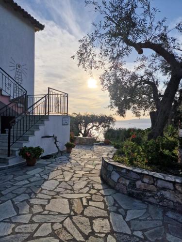 a stone walkway in front of a house with a tree at Nemesis in Neo Klima