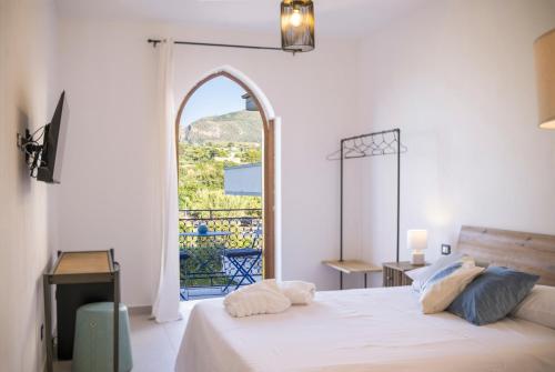 a bedroom with a bed and an arch window at Le Tartane B&b Guidaloca in Castellammare del Golfo