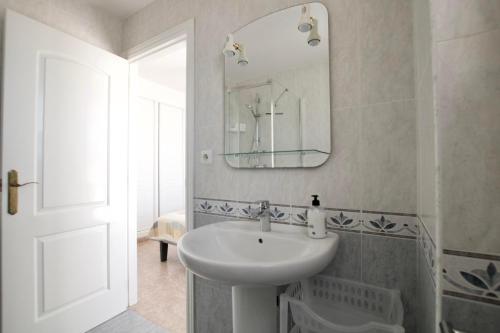 Un baño blanco con lavabo y espejo. en Villa Noma, en El Campello