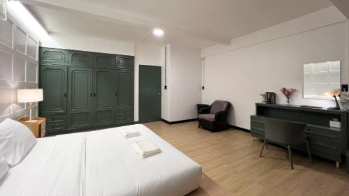 a bedroom with a bed and a desk and a computer at Neveu Premier Residence : Ratchada in Bangkok