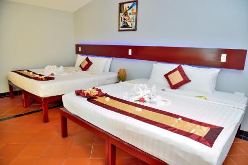 美奈的住宿－泰好亞美奈度假酒店，配有白色床单的酒店客房内的两张床
