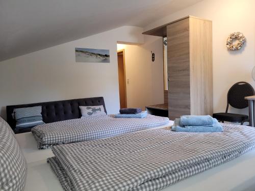a bedroom with two beds and a cabinet at Pension Turm in Schönwald