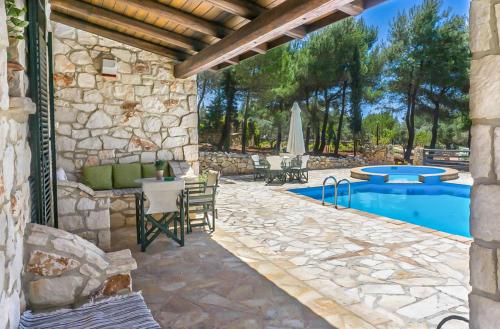 a patio with a pool and a table and chairs at Villa Lida Aresti in Agios Leon