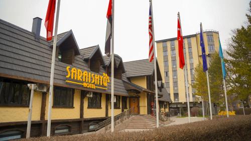 a building with flags in front of a building at Saraishyq Hotel in Almaty