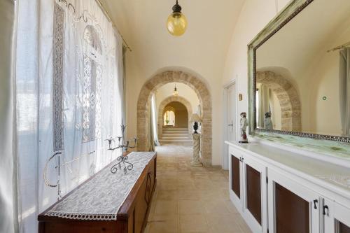 a bathroom with a large mirror and a sink at Masseria Cucuruzza Boutique Hotel in Felline