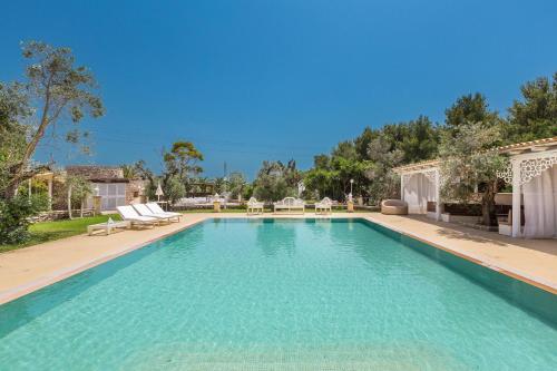 una piscina con acqua blu in un cortile di Masseria Cucuruzza Boutique Hotel a Felline