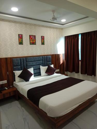a bedroom with a large bed in a room at Hotel Sun Shine in Ahmedabad