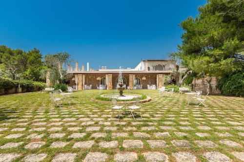 a large yard with a fountain in front of a building at Masseria Cucuruzza Boutique Hotel in Felline
