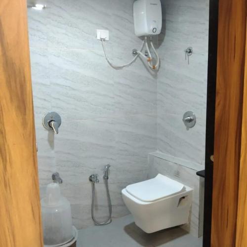 a bathroom with a white toilet and a shower at Hotel Sun Shine in Ahmedabad