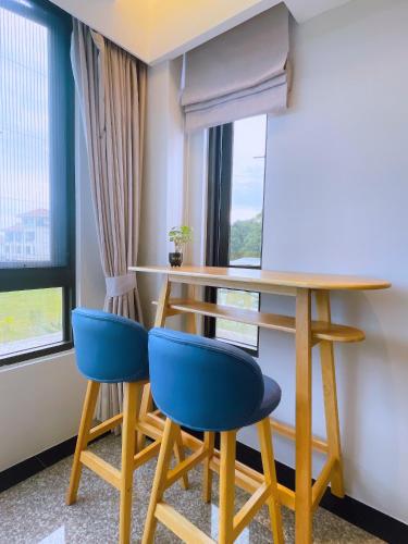 a table and two blue chairs in a room with a window at 花蓮壽豐 - Twinkle Night 星空說民宿A館 in Zhixue