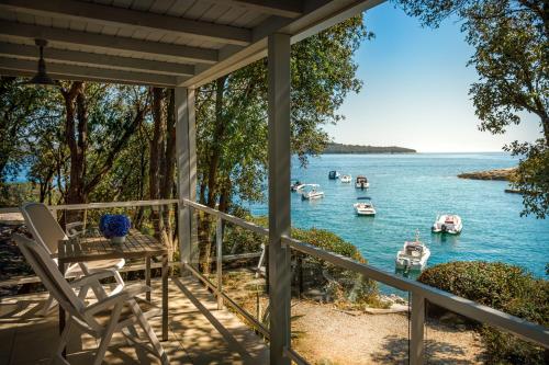 un porche con mesa, sillas y barcos en el agua en Maistra Camping Koversada Naturist Mobile homes, en Vrsar