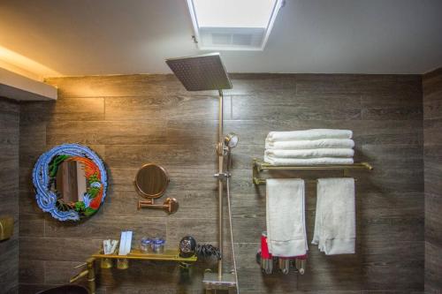 y baño con ducha, toallas y espejo. en Tengchong Old Town Peace Inn en Tengchóng