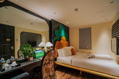 a bedroom with a bed and a desk with a desk at Hanoi Center Silk Classic Hotel & Travel in Hanoi