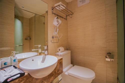 a bathroom with a sink and a toilet and a mirror at Hanoi Center Silk Classic Hotel & Travel in Hanoi
