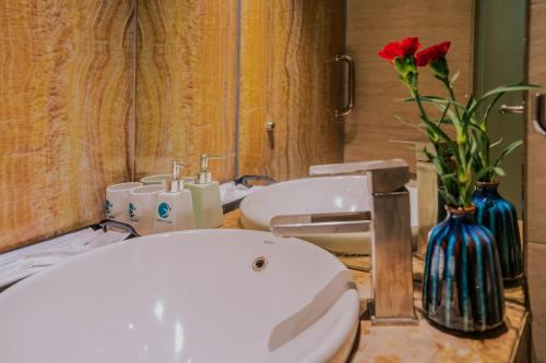 a bathroom with a toilet and a vase with flowers at Hanoi Center Silk Classic Hotel & Travel in Hanoi