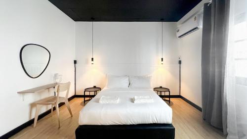 a bedroom with a bed and a desk and a mirror at Neveu Premier Residence : Ratchada in Bangkok