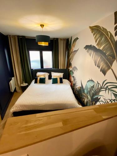 une chambre avec un lit avec une fresque végétale sur le mur dans l'établissement Superbe appartement terrasse et parking gratuit, à Auxerre