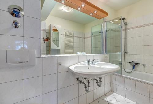 a white bathroom with a sink and a shower at Am Schloonsee Haus A in Heringsdorf
