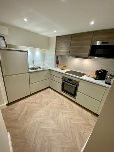 Il comprend une cuisine dotée de parquet et d'une cuisinière. four supérieur dans l'établissement Superbe appartement terrasse et parking gratuit, à Auxerre