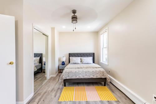 a bedroom with a bed and a yellow rug at Full modern 1Bdr Apt w/ Private Entrance on 2nd FL in Bethpage