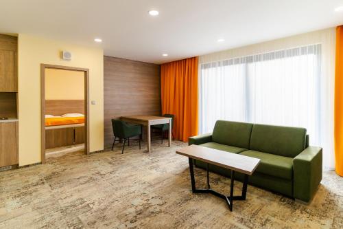 a room with a couch and a table and a bed at Spa & Wellness Hotel Fitak**** in Liptovský Ján