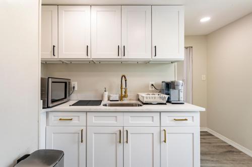 a kitchen with white cabinets and a sink at Full modern 1Bdr Apt w/ Private Entrance on 2nd FL in Bethpage