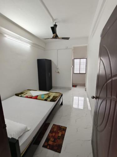 a white room with a bed and a ceiling at Jungle Eco Mansion in Kāziranga
