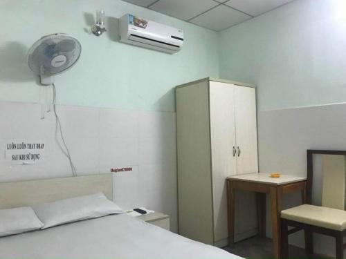 a hospital room with a bed and a desk and a fan at Nhà Nghỉ Thư Giản in Tây Ninh