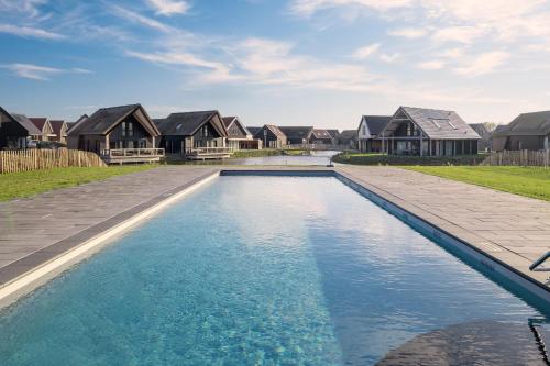 a swimming pool in front of some houses at Dormio Resort Nieuwvliet-Bad in Nieuwvliet