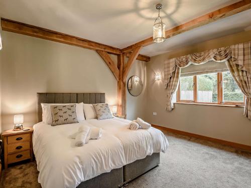 Schlafzimmer mit einem Bett mit weißer Bettwäsche und einem Fenster in der Unterkunft 6 Bed in Kings Lynn 90964 in Clenchwarton