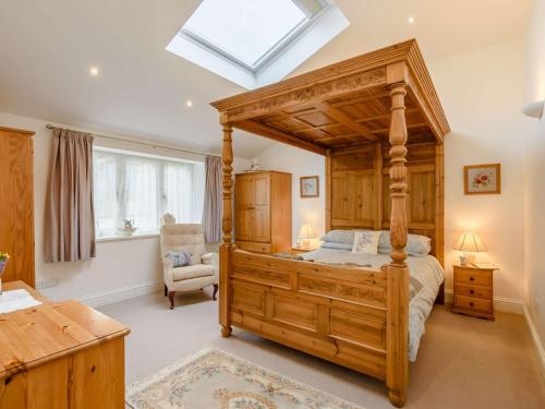 a bedroom with a wooden canopy bed and a chair at 1 Bed in Gamblesby 91164 in Kirkoswald